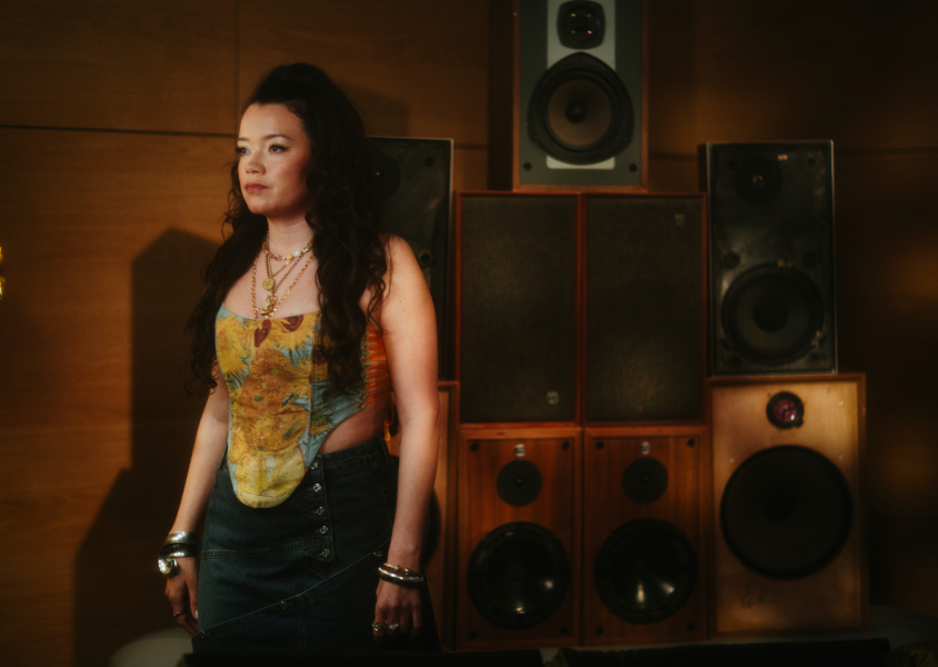 Musician Clementine Douglas standing in front of speakersx